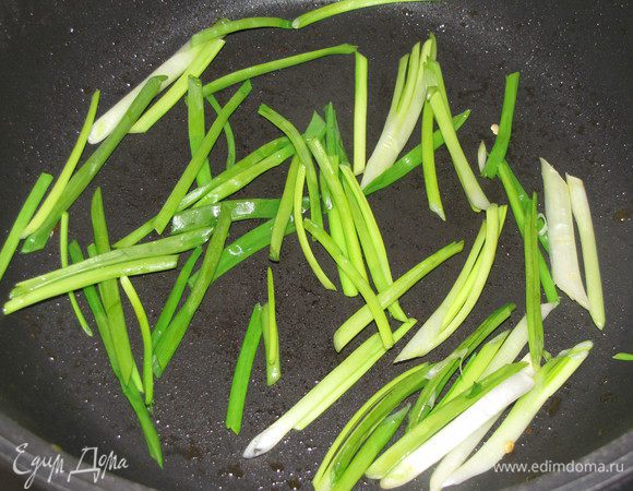 В этой же сковороде обжарить лук 3 минуты. Переложить в миску с перцами.