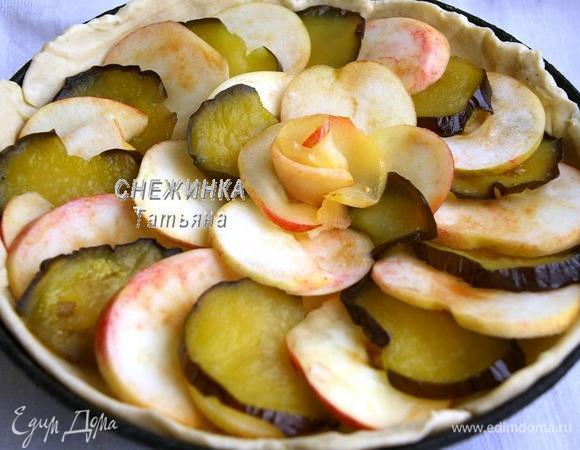 На тесто внахлёст укладываем чередуя кружочки яблок и баклажана в два ряда. В центре можно украсить «розой» из яблока, предварительно опустив половинки яблочных колец в сироп от баклажанов.