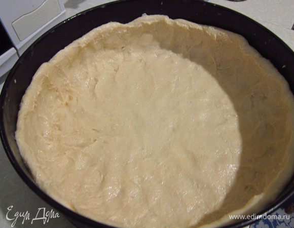 В разъемную форму выложить тесто, сформировав бортики.