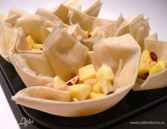 Формочки для маффинов слегка смазать маслом (или маргарином!). Промазать один лист слоёного теста маслом, положить второй лист сверху. Разрезать пополам. Одну половину смазать маслом, положить вторую сверху. Нарезать ещё раз пополам, теперь поперёк. Так же поступить с остальными листами слоёного теста. Выложить тесто в полученных четыре слоя в формочки.