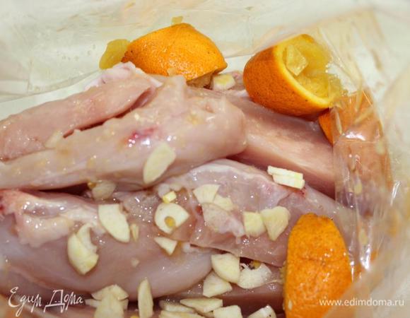 Куриную грудку освободить от кожи и грудной кости, нарезать на продольные кусочки, уложить в пакет для запекания. Добавить нарезанный чеснок, сок двух апельсинов и нарезанную на дольки кожуру апельсинов.