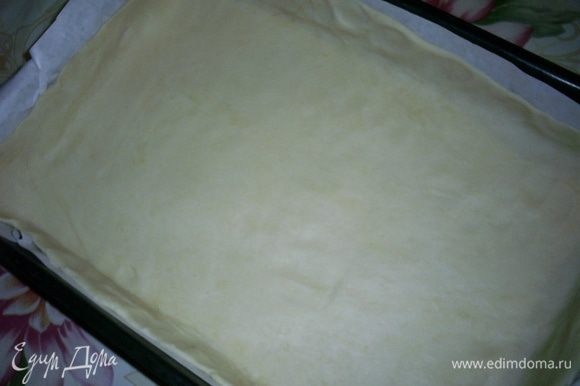 Тесто раскатываем в тонкий пласт. Удобно это делать прямо на бумаге для выпечки. Затем вместе с бумагой перекладываем тесто в форму для выпекания.