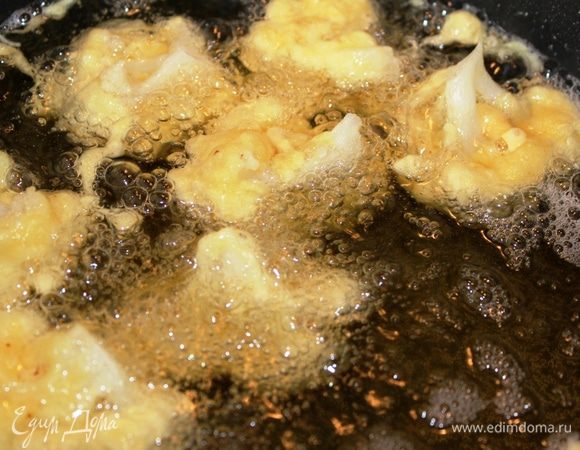 Осторожно (с помощью вилки или щипцов) опустить их в горячее масло. Масла должно быть достаточно много, чтобы кусочки капусты могли утонуть.