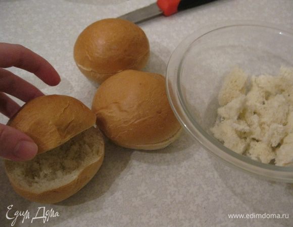 Варим перепелиные яйца.
Разрезаем булочки по середине, но не до конца. Из нижней части вынимаем мякиш в миску.