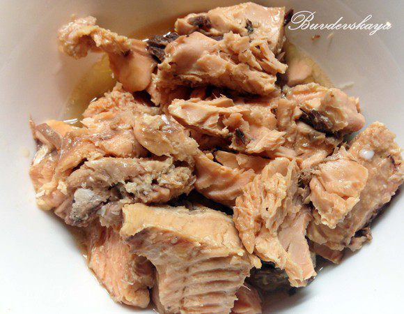 Открыть банку с рыбой, сок перелить в миску (НЕ ВЫЛИВАТЬ !) . Отделить рыбу от кожи и костей, переложить в миску с соком и размять вилкой. Выложить слой рыбы на белок, немного поперчить.