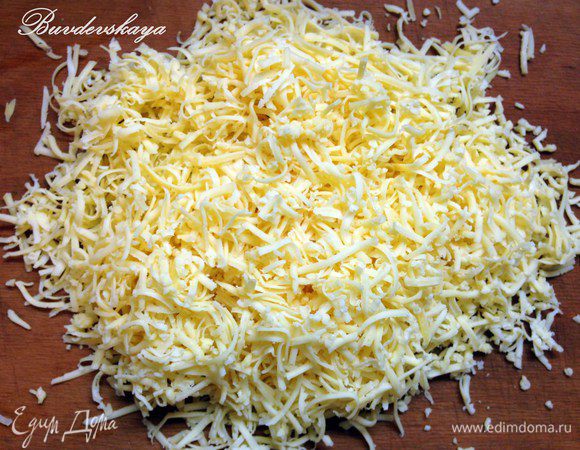 На мелкой терке натереть сыр. Если сыр очень мягкий, его можно положить минут на 10 в морозилку, чтобы удобнее было тереть. Выложить слой сыра на лук.