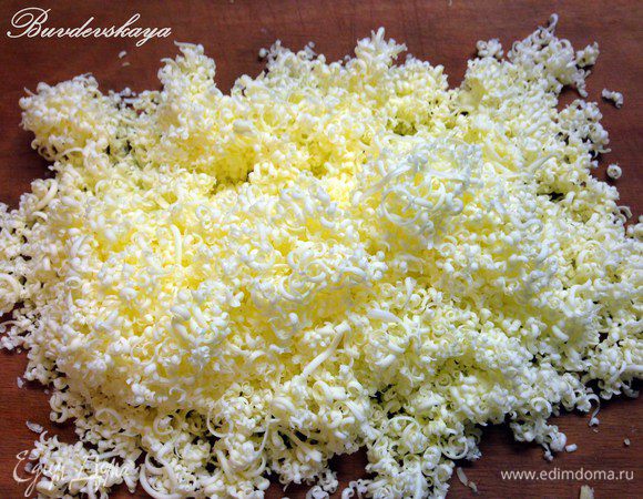 На мелкой терке натереть сливочное масло и аккуратно выложить на сыр. Если салат выкладывается на общую тарелку, то его нужно слегка прижать, придав форму тортика. Немного смазать майонезом.