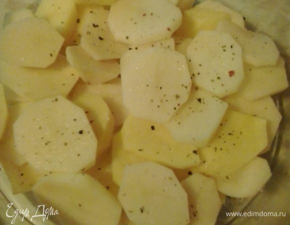 Дно стеклянной формы слегка смазываем масло. На дно формы выкладываем картофель, нарезанный кружочками, слегка солим и перчим.