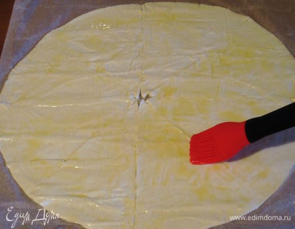 Раскатать тесто и разделить на 10 треугольников. Сыр разрезать на 10 одинаковых кусочков. Треугольники смазать взбитым яйцом.