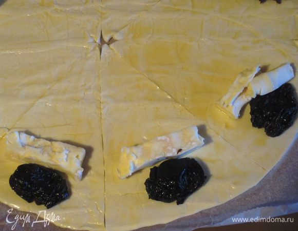 На край каждого сегмента положить чернослив и кусочек сыра.