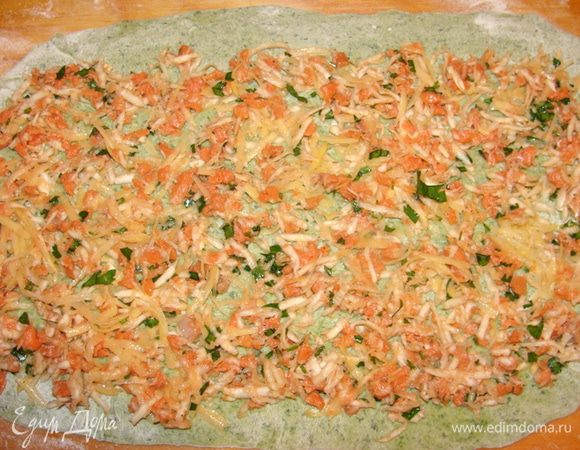 Часть фарша разложить поверх раскатанного пласта.