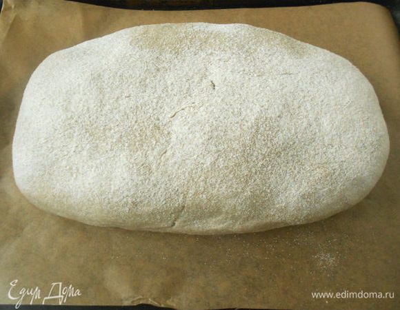 Обсыпьте верх и бока пирога ржаной мукой.
Переложите его на противень, застеленный бумагой для выпечки.