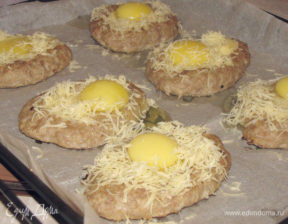 Затем в каждое углубление аккуратно вбиваем яйцо. У меня два яйца наполовину вытекли, т.к. ямка была не достаточно большая.  Опять присыпаем сыром, но только вокруг желтка. И ставим в духовку еще минут на 15-20. Края должны зарумяниться, в желток оставаться не совсем запеченным.