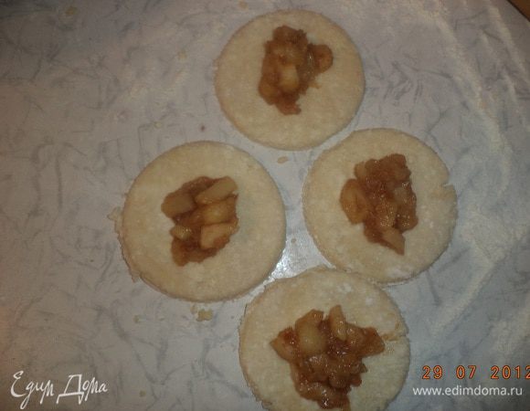 Тесто тонко раскатать и вырезать из него чашкой кружочки. На каждый кружок выложить по 1 ст. л. яблочно-коричной начинки и соединить края, сформировав пирожки.