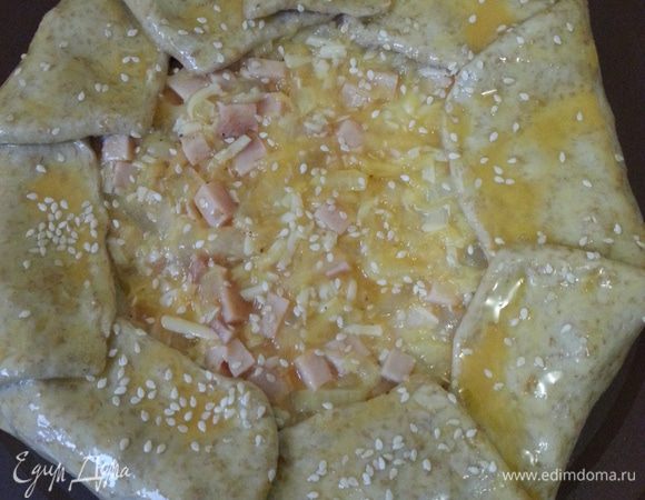 Заворачиваем края, смазываем желтком, посыпаем кунжутом. Ставим в заранее разогретую до 175°С духовку на 40-45 минут.