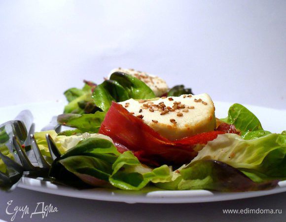 Достаём сыр из духовки, перчим, выкладываем на салат или рядом с салатом. Кунжут, который хорошенько просушился, распределяем по салату. Подаём с багетом, например, ячменным или из полбы. Всё разнообразие.