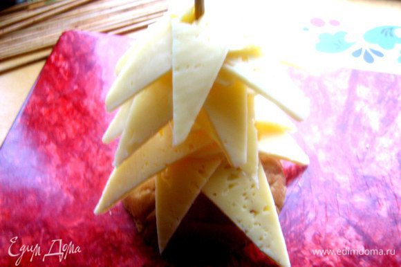 Распределяем равномерно кусочки сыра в виде веток ёлочки.