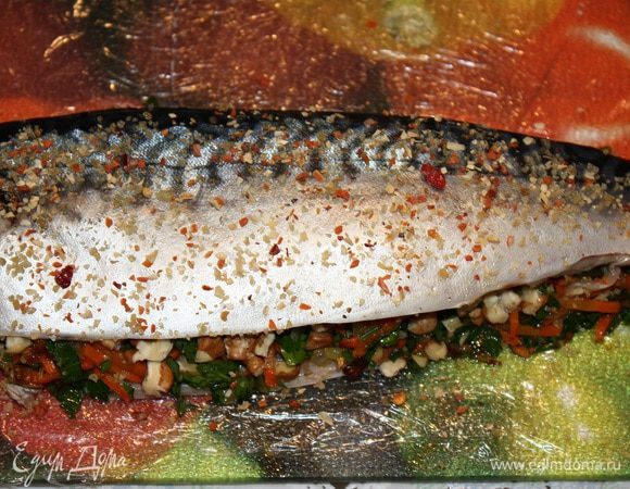 Выкладываем начинку. Немного орехов, затем овощи и опять орехи.
Накрываем второй половиной рыбы. Прижимаем.