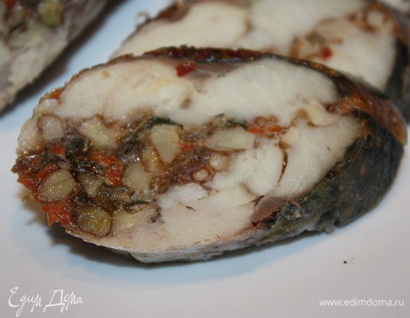 Достаем скумбрию и охлаждаем ее при комнатной температуре. Можно положить ее под легкий гнет и оставить на балконе до утра. Только не снимайте нитки и пленку.
Утром (или перед подачей) снимите нитки и пленку. И мы видим очень симпатичную рыбку в блестящей желатиновой оболочке и снаружи и мозаичным слоем начинки внутри.