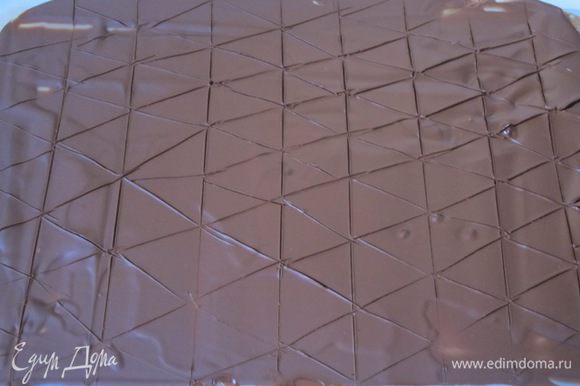 Выложить растопленный шоколад на полиэтиленовый файл, размазать, положить в холодильник, чтобы шоколад схватился. Ножом наметить треугольники.