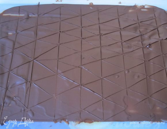 Выложить растопленный шоколад на полиэтиленовый файл, размазать, положить в холодильник, чтобы шоколад схватился. Ножом наметить треугольники.