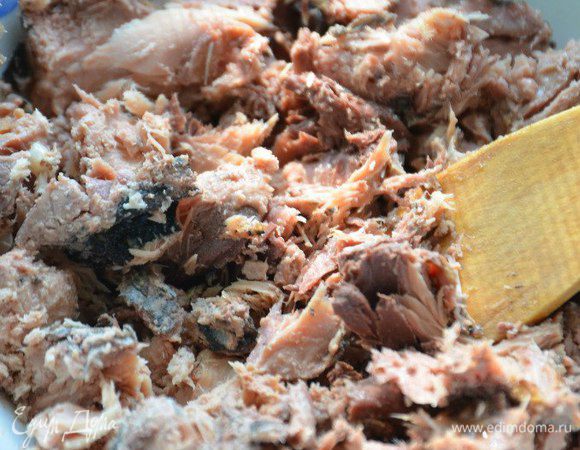 Слить масло из консервы, размять рыбу.