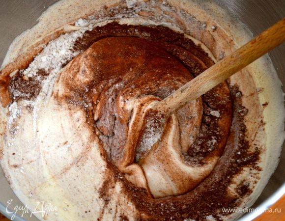 Просеять муку, крахмал и какао-порошок. Ввести частями сухие ингредиенты в яичную смесь, каждый раз аккуратно перемешивая лопаткой движениями снизу вверх, чтобы воздушная масса не опала. Переложить тесто в подготовленную (смазанную маслом и присыпанную мукой) форму диаметром 24 см. И поставить выпекаться бисквит в разогретую духовку примерно на 45 минут. В любом случае ориентироваться по своей духовке и готовность бисквита проверить деревянной шпажкой.