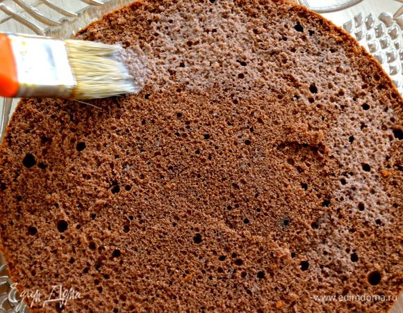 Подогреть 200 мл молока. Первый нижний корж положить на сервировочное блюдо. Смочить его горячим молоком с помощью кисточки.