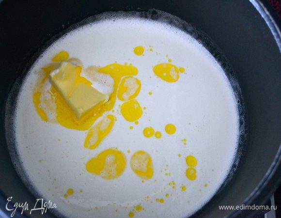 Накрываем последним третьим коржом и смачиваем его остатками молока. Отставить в сторону, желательно в прохладное место. Готовим шоколадный ганаж для украшения торта. В кастрюльку налить сливки и добавить мягкое сливочное масло (20 г). Ставим на очень слабый огонь и, помешивая, даем маслу полностью растаять.