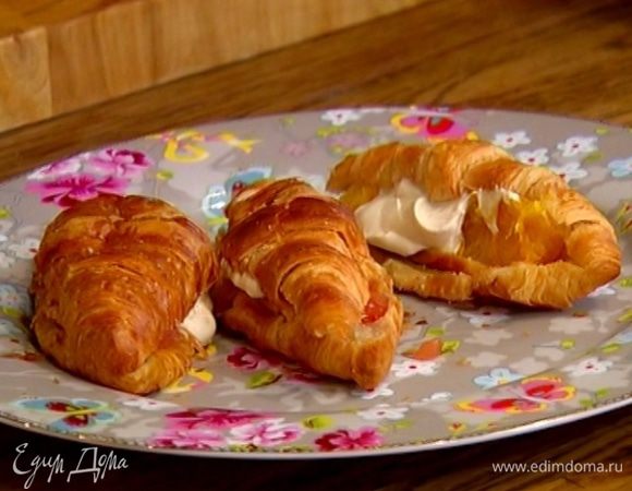 Выложить на одну половинку круассана цитрусовую начинку, полить сметанным соусом и накрыть второй половинкой.