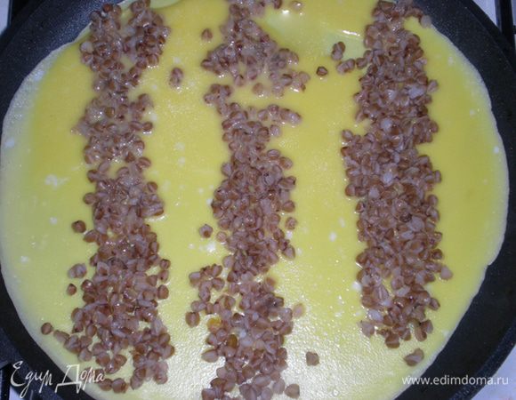 Теперь на теплую, но не горячую (!) сковороду влить треть теста. И быстро распределить 2 ст.л. гречневой каши по блинчику в виде полосок.  Блинчик жарим под крышкой только с одной стороны. То же проделываем с остальным тестом. У меня получилось три блинчика. У меня сковорода  диаметром 20 см.