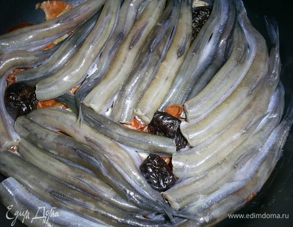Затем плотно укладываем в кастрюльку мойву, спинками вверх, и чернослив между рыбками. У меня получилось два слоя. Если рыбку уложить неплотно, во время кипения она может поломаться.