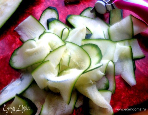 Молоденький цукини (или кабачок) нарезать с помощью овощечистки на тонкие пластинки.