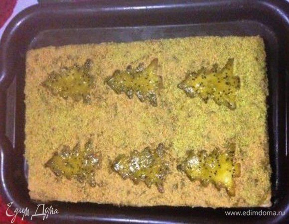 Сверху выложить корж с выдавленными елочками, распределить по нему оставшийся джем и посыпать промежутки между елочками крошкой из обрезков коржей.