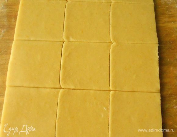 Раскатайте тесто тонким слоем на посыпанной мукой поверхности. Нарежьте ножом квадраты (около 6 х 6 см). Разложите на два противня, застеленных бумагой для выпечки.