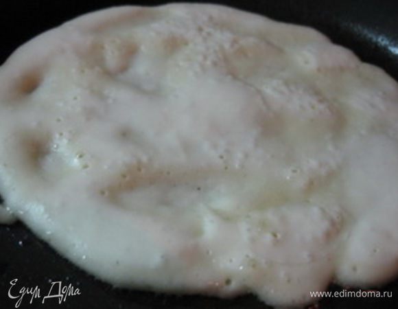 Приготовить тесто из кефира, муки, щепотки соли, сахара и соды. Тесто должно получиться как сметана (может чуть жиже, чем на оладьи).
Нагреть сковороду, слегка промазать ее растительным маслом, выложить часть теста в центр сковороды и слегка размазать его придавая круглую форму.