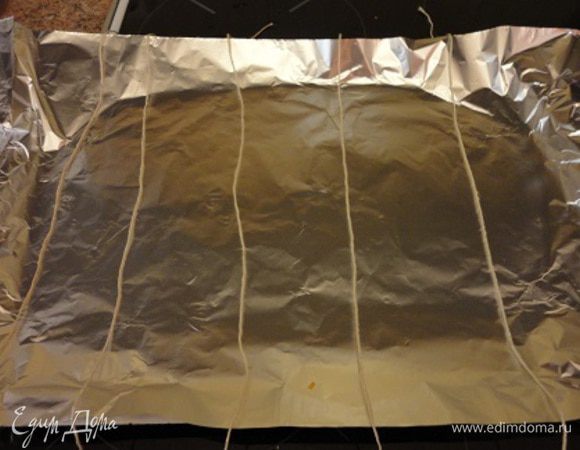 Обсушить филе лосося с помощью бумажных полотенец и сделать несколько глубоких надрезов на коже. Фольгу положить на лист для запекания и на него нитки, которыми будете перевязывать рыбу.