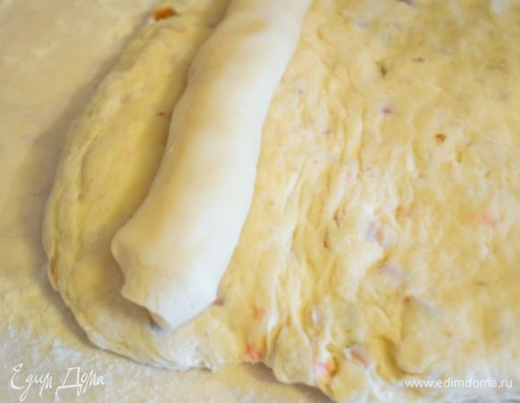 Положить ее на край теста и скатать в рулет.