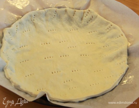 Тесто предварительно вынуть из морозилки, если дрожжевое - дать подняться. Выложить тесто на смазанную маслом пекарскую бумагу, наколоть вилкой по всей площади коржа, выложить в форму с невысокими бортиками, поставить в разогретую до 160*С духовку на 10-14 минут.