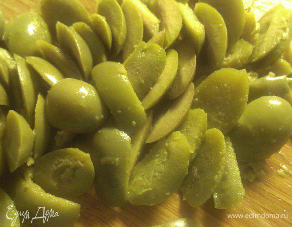 Оливки разрезать пополам.