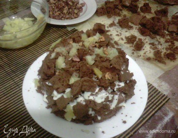 Выкладываем торт горкой, сверху смазываю кремом и украшаю орехами и ананасом.