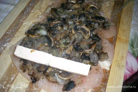 Приступаем к формированию рулетиков. На каждый выкладываем четвертую часть грибной начинки и брусочки плавленного сыра.