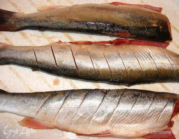 Рыбу очистить от внутренностей и чешуи. Если размер сковороды позволяет или вы будете готовить на углях, голову можно оставить. Мне пришлось голову и даже хвост отрезать, чтобы рыбка уместилась на сковороде. У рыбы сделать надрезы наискось с обеих сторон.