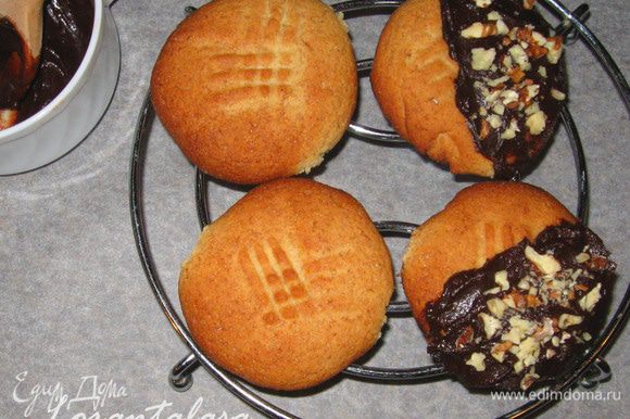 Половинку каждого печенья обмакнуть в растопленный шоколад и посыпать орехами.