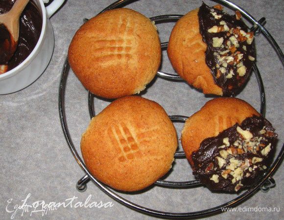 Половинку каждого печенья обмакнуть в растопленный шоколад и посыпать орехами.