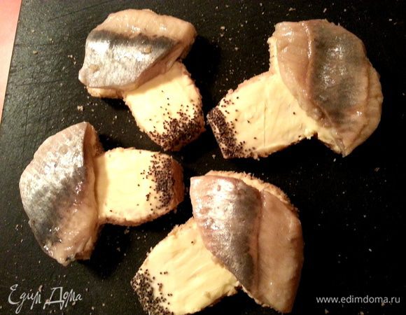 И накладываем кусочки сельди на шляпки. Неровности обрезаем!