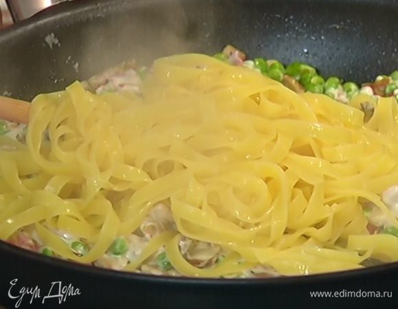 Шумовкой вынуть из кастрюли готовые макароны и переложить в сковороду с грибами и горошком, влить 1 половник воды, в которой они варились и, непрерывно перемешивая, прогревать еще пару минут, затем снять с огня.