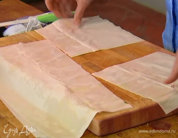 Пласт теста фило смазать растопленным сливочным маслом, сверху положить второй пласт теста и разрезать на 4 квадрата.