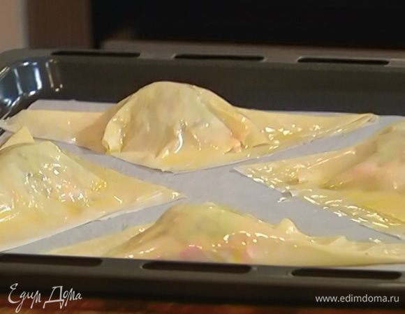 Смазать конвертики растопленным маслом, выложить на застеленный бумагой для выпечки противень и отправить в разогретую духовку на 10–12 минут.