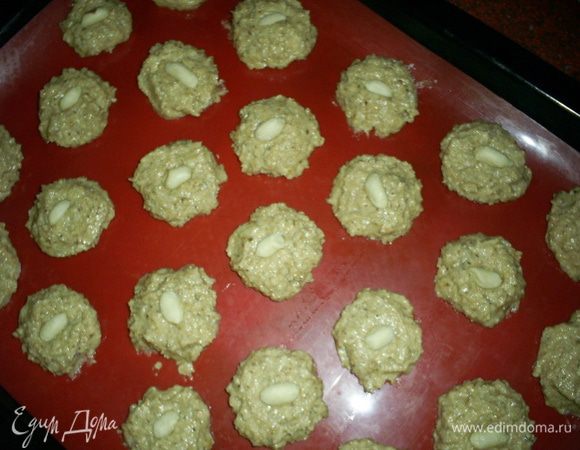У нас получается густое тесто. Руками с ним работать нельзя. Набираем тесто чайной ложечкой и с помощью другой чайной ложки формируем небольшие шарики. Выкладываем их на противень с пергаментом или силиконовым ковриком. Места между шариками оставляем не меньше двух сантиметров. На фото первая порция, некоторые печеньки после выпечки слиплись.
Выпекаем в разогретой до 190-200 градусов духовке примерно 15 минут. Когда краюшки печенюшек зарумянятся, можно вынимать из духовки. Печенье сначала мягкое в центре, после остывания оно еще немного затвердеет. Приятного аппетита!!!